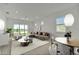 Bright and airy living room featuring modern furnishings, neutral tones, and a sliding glass door at 10399 Abaco Falls Dr, Englewood, FL 34223