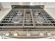 Close up of the stainless steel gas range with 4 burners, illuminated with blue flames at 10399 Abaco Falls Dr, Englewood, FL 34223
