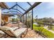 Serene backyard with a pool, lounge chairs, and beautiful water views with tropical landscaping around the screened in lanai at 10139 Kansas City St, Port Charlotte, FL 33981