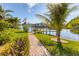 Tranquil backyard with a paver path leading to a private dock, showcasing beautiful waterfront views at 10139 Kansas City St, Port Charlotte, FL 33981