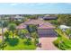 Beautiful home with a red tile roof, well-manicured lawn, lush landscaping, and a brick driveway at 10139 Kansas City St, Port Charlotte, FL 33981