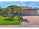 Stunning home with a red tile roof, a lush green lawn, manicured landscaping, and a brick-paved driveway at 10139 Kansas City St, Port Charlotte, FL 33981
