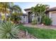 Stunning home entrance featuring a brick walkway, beautiful garden, and elegant architectural details at 10139 Kansas City St, Port Charlotte, FL 33981
