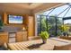 Beautiful screened outdoor dining and kitchen area with a TV, mini fridge, and seating at 10139 Kansas City St, Port Charlotte, FL 33981