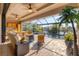 Screened outdoor living space with outdoor kitchen, seating, water views, and a pool at 10139 Kansas City St, Port Charlotte, FL 33981