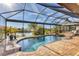 A screened-in pool area features a relaxing spa and views of the serene waterfront at 10139 Kansas City St, Port Charlotte, FL 33981
