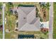 Birds-eye view captures the unique roof design and landscaped grounds, highlighting the property's meticulous maintenance and curb appeal at 1048 Ulrey Ln, Englewood, FL 34223