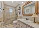 This bathroom has a glass shower, a bright vanity, and tiled floors at 1048 Ulrey Ln, Englewood, FL 34223