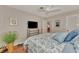 This bedroom has hardwood floors, a ceiling fan, a bed, and a dresser with TV at 1048 Ulrey Ln, Englewood, FL 34223