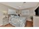 This bedroom has hardwood floors, shuttered windows, a bed, and a dresser with TV at 1048 Ulrey Ln, Englewood, FL 34223