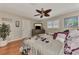 This bedroom features a ceiling fan, wood flooring, and a large decorative plant at 1048 Ulrey Ln, Englewood, FL 34223