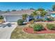 Charming single-story home with well-manicured landscaping, including palm trees and colorful mulch beds at 1048 Ulrey Ln, Englewood, FL 34223