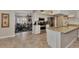 Bright kitchen and living area featuring stainless appliances, granite counters, and neutral tile flooring at 1048 Ulrey Ln, Englewood, FL 34223