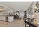 Open-concept kitchen and dining area with tile flooring and natural light, adjacent to office space at 1048 Ulrey Ln, Englewood, FL 34223