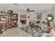 Open living room with tile floors, ceiling fan, built in bookcase, and view to adjacent office at 1048 Ulrey Ln, Englewood, FL 34223