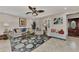 Comfortable living room with ceiling fan, tile floor, shuttered windows, blue accents and eclectic decor at 1048 Ulrey Ln, Englewood, FL 34223