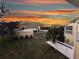 Serene backyard showcasing the home's well-maintained lawn, lush landscaping, and tranquil surroundings in the evening at 109 Bayshore Rd # 10, Nokomis, FL 34275