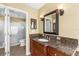 A bathroom with dual vanities, wood cabinets, granite counters, and a walk-in shower at 109 Bayshore Rd # 10, Nokomis, FL 34275