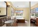 This bathroom features a bathtub, a makeup vanity, tile flooring, and a window at 109 Bayshore Rd # 10, Nokomis, FL 34275