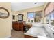 This bathroom features a soaking tub, a vanity, natural light, and tile floors at 109 Bayshore Rd # 10, Nokomis, FL 34275