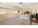 Spacious bedroom with a ceiling fan, floral bedding, a sitting area, and carpet flooring at 109 Bayshore Rd # 10, Nokomis, FL 34275