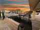 Private dock with boats, offering direct water access and stunning waterfront views at sunset at 109 Bayshore Rd # 10, Nokomis, FL 34275