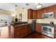 This kitchen features brown cabinets, stainless steel appliances, a breakfast bar, and wood floors at 109 Bayshore Rd # 10, Nokomis, FL 34275