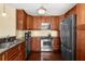 A kitchen featuring stainless steel appliances, brown cabinets, and hardwood floors at 109 Bayshore Rd # 10, Nokomis, FL 34275