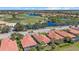 Overhead shot of a residential community with serene lakes, a golf course, palm trees, and tile roofs at 124 Pesaro Dr, North Venice, FL 34275