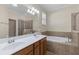 Elegant bathroom featuring double sinks, a soaking tub, and a tiled shower at 12565 Canavese Ln, Venice, FL 34293