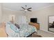 Bedroom with floral bedding, dresser with television, and view into the bathroom at 12565 Canavese Ln, Venice, FL 34293