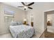 Comfortable bedroom features a ceiling fan, seaside-themed decor, and a bright ensuite bathroom at 12565 Canavese Ln, Venice, FL 34293
