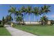 Community entrance sign is beautifully landscaped with a stone wall, inviting atmosphere and palm trees at 12565 Canavese Ln, Venice, FL 34293