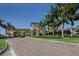 Elegant community entrance with stone archway, lush landscaping, and stately design at 12565 Canavese Ln, Venice, FL 34293