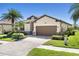 Beautiful one-story home boasting lush landscaping, a paver driveway, and a two-car garage at 12565 Canavese Ln, Venice, FL 34293