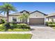 Charming home featuring a tile roof, lush landscaping, and a paved driveway at 12565 Canavese Ln, Venice, FL 34293