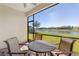 Screened patio with comfortable seating overlooks a scenic lake and beautifully landscaped grounds at 12565 Canavese Ln, Venice, FL 34293