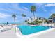 Community pool with clear blue water, lounge chairs and palm trees at 1555 Tarpon Center Dr # 255, Venice, FL 34285