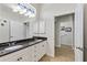 Bathroom featuring dual sinks with granite countertops, white cabinets, and tiled flooring at 1572 Monarch Dr, Venice, FL 34293