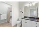 Neutral bathroom with a marble countertop, white cabinets, a walk-in shower, and decorative fish accents at 1572 Monarch Dr, Venice, FL 34293