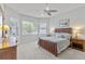Bright bedroom featuring a ceiling fan, wood furniture, and large windows with blinds at 1572 Monarch Dr, Venice, FL 34293