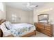 Bright bedroom with a large window, a wood dresser with a mirror, and nautical-themed bedding at 1572 Monarch Dr, Venice, FL 34293