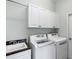 Well-equipped laundry room with modern washer and dryer, ample cabinet space, and a utility sink at 1572 Monarch Dr, Venice, FL 34293