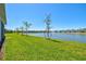 Manicured backyard with pond views and lush green lawns stretching to the water at 1606 Cedar Valley Dr, Port Charlotte, FL 33953