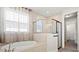 Bright bathroom featuring a shower, large tub, and window with natural lighting at 1606 Cedar Valley Dr, Port Charlotte, FL 33953