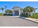 Inviting clubhouse exterior featuring a well-maintained lawn, palm trees, and manicured landscaping at 1606 Cedar Valley Dr, Port Charlotte, FL 33953