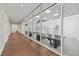 Bright fitness center entrance, featuring glass walls, wood flooring, and gym equipment beyond at 1606 Cedar Valley Dr, Port Charlotte, FL 33953