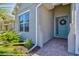 Close up of a beautiful, bright, front door with sidelight, brick walkway, and pretty landscaping at 1606 Cedar Valley Dr, Port Charlotte, FL 33953