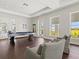 Modern game room with a pool table, comfortable seating, and exterior views through bright windows at 1606 Cedar Valley Dr, Port Charlotte, FL 33953