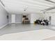 Spacious garage featuring epoxy flooring, a golf cart, and a custom bar area for entertaining at 1606 Cedar Valley Dr, Port Charlotte, FL 33953